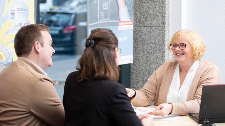 Beraterin mit zwei Ratsuchenden in einem Büro